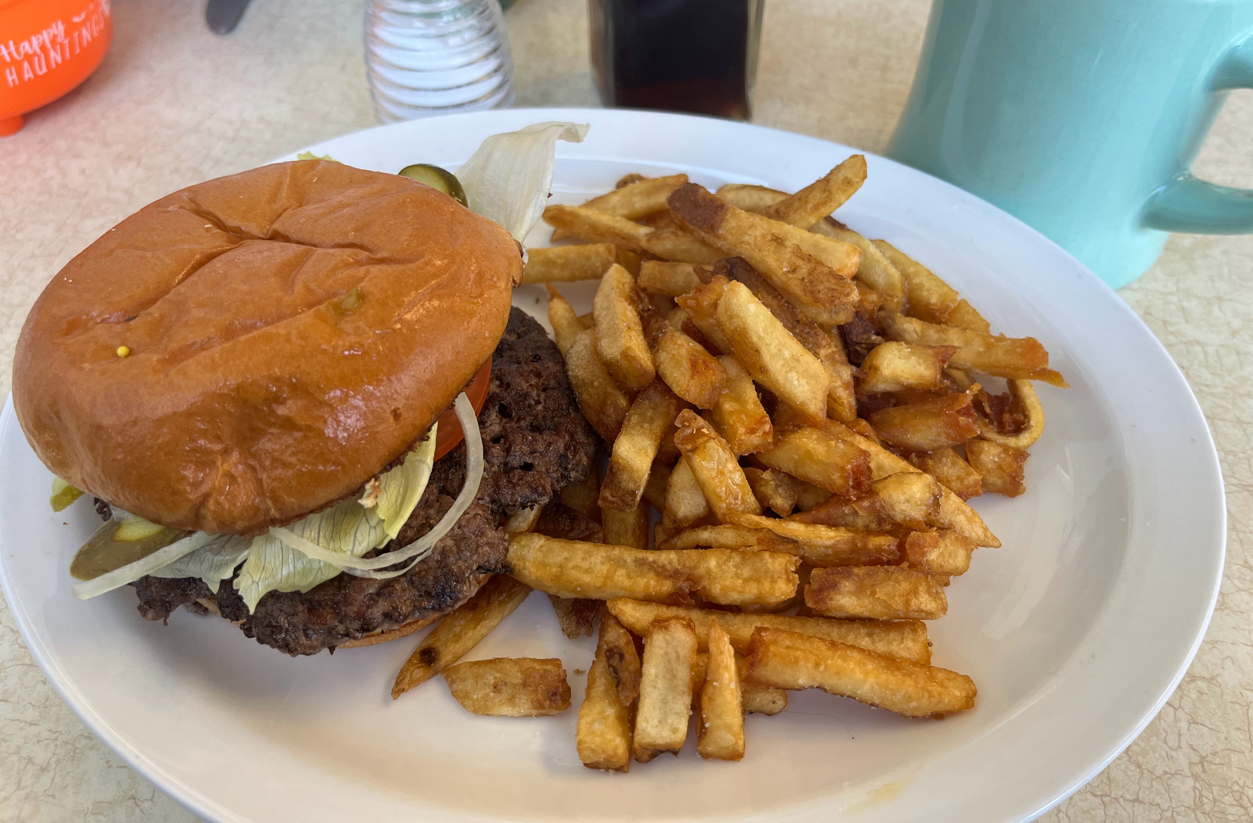 A smash burger loaded with toppings on a wooden board