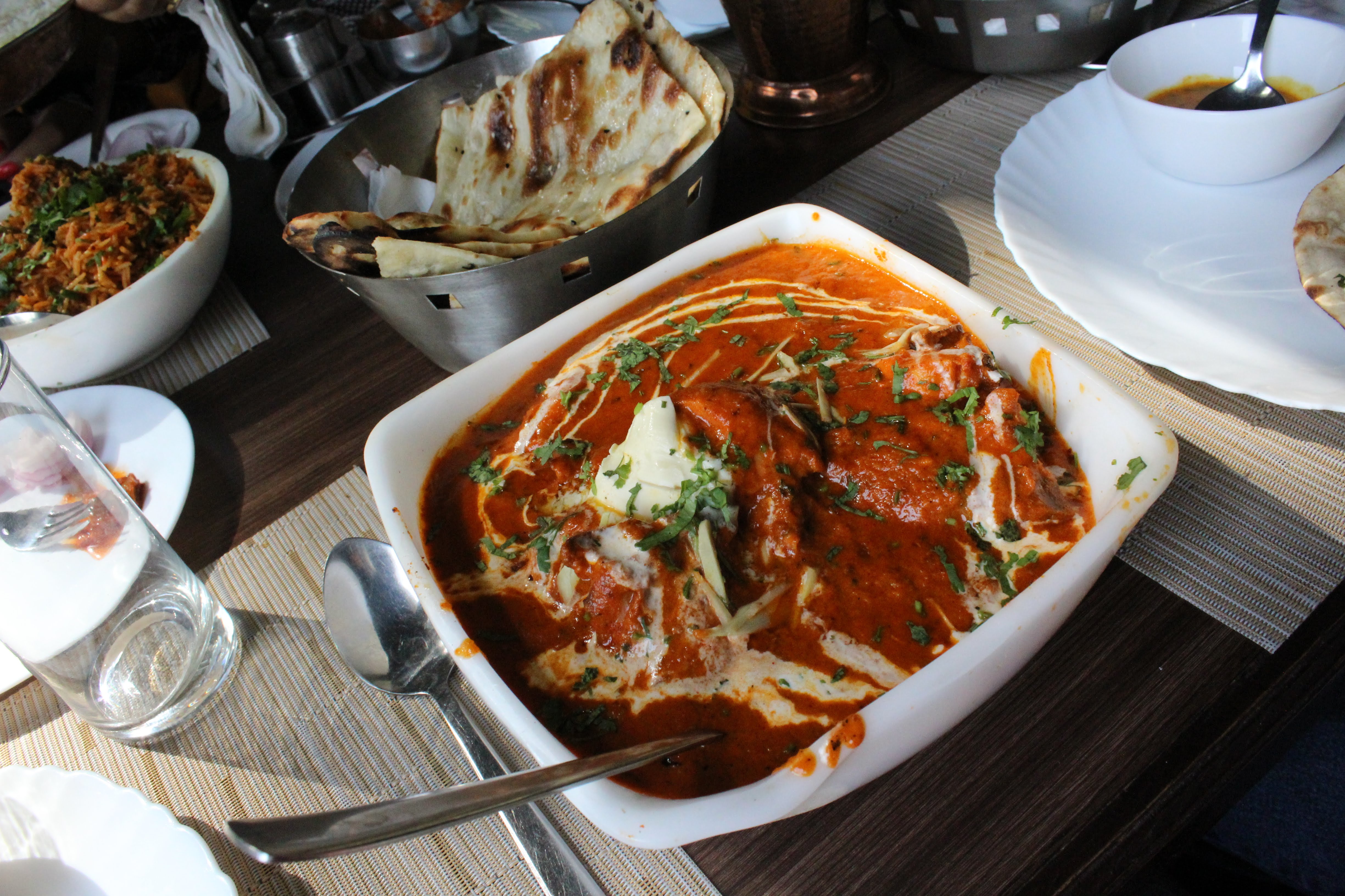 Overhead shot of a curry dish with rice and naan